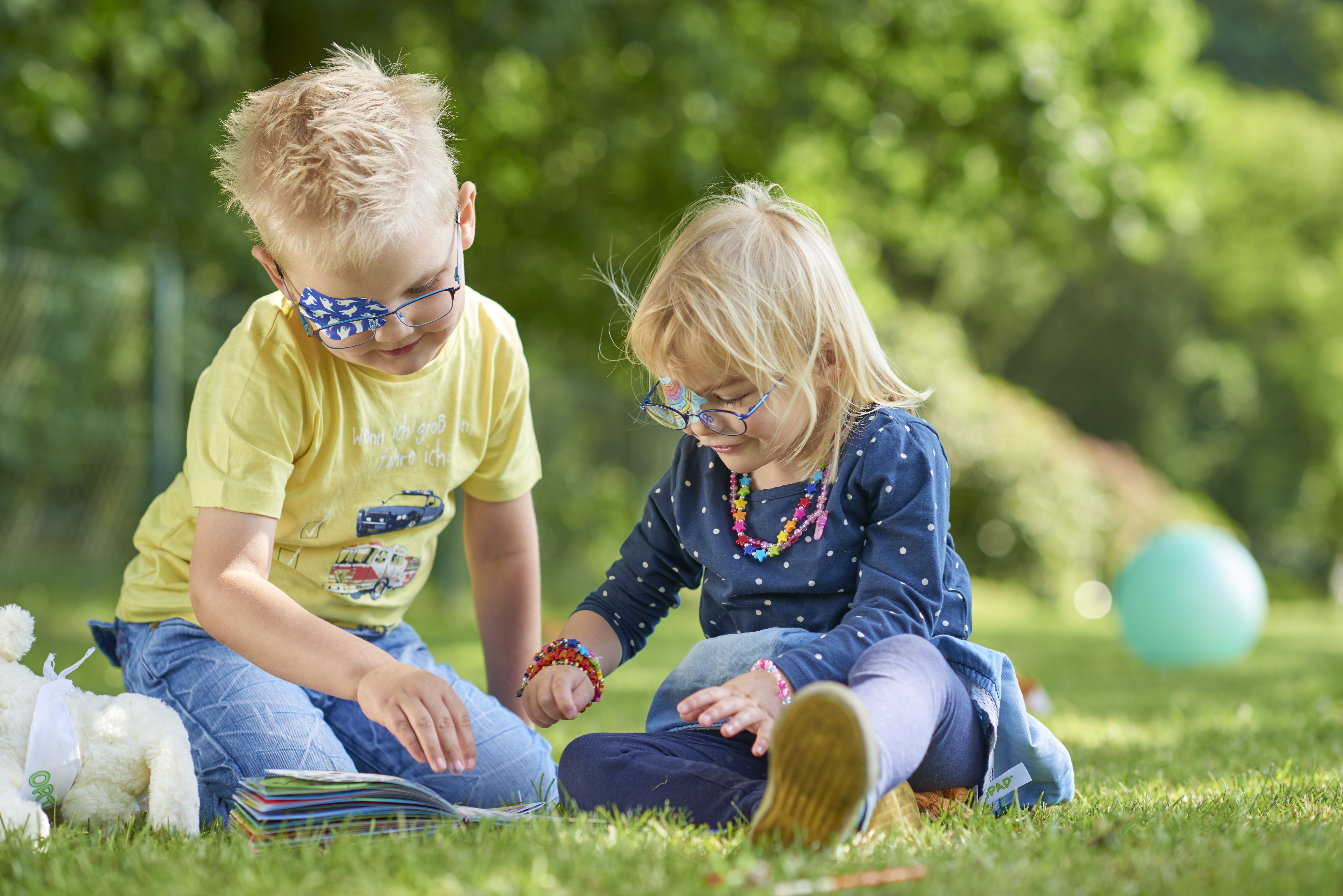 Kopafbeelding spelende kinderen met ORTOPAD®-oogpleisters spoken en regenbogen